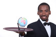 Waiter holding miniature globe on tray