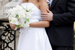 bride and groom's hands holding wedding bouquet