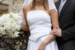 bride and groom's hands holding wedding bouquet