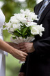 bride and groom's hands holding wedding bouquet