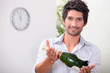Photos : Man offering a bottle of champagne at five minutes to midnight