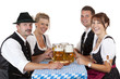 Foto: Bayrische Männer und Frauen stossen mit Oktoberfest Maß Bier an Bayrische Männer und Frauen stossen mit Oktoberfest Maß Bier an