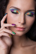 Woman with professional colourful make-up and sparkling manicure