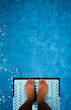 feet on diving board over pool