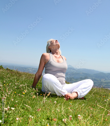 Photo: Senior woman doing stretching exercises in countryside Senior woman doing stretching exercises in countryside