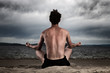 Man in the meditation on the shore of the sea