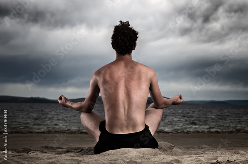 Photo: Man in the meditation on the shore of the sea Man in the meditation on the shore of the sea