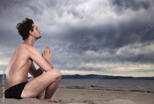 Photo: Man in the meditation on the shore of the sea Man in the meditation on the shore of the sea