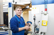 Foto: worker operating CNC machine center worker operating CNC machine center