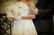 bride and groom's hands holding wedding bouquet