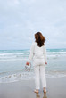 Barefooted woman on the beach against sea and cloudy sky.