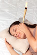 Photo: Woman having with ear candle treatment Woman having with ear candle treatment