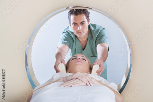 Photo: Young woman going through CT test Young woman going through CT test