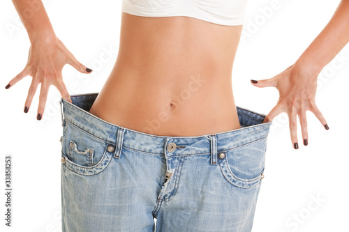 Photo: Funny woman shows her weight loss by wearing an old jeans Funny woman shows her weight loss by wearing an old jeans
