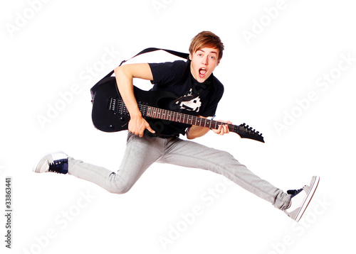 Foto: Young teenager jumping with guitar Young teenager jumping with guitar