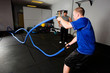 Workout with a rope in a gym with a trainer