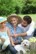 Family with small white dog and basket of vegetables