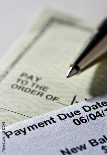 Photo: Personal check and credit card statement with pen Personal check and credit card statement with pen