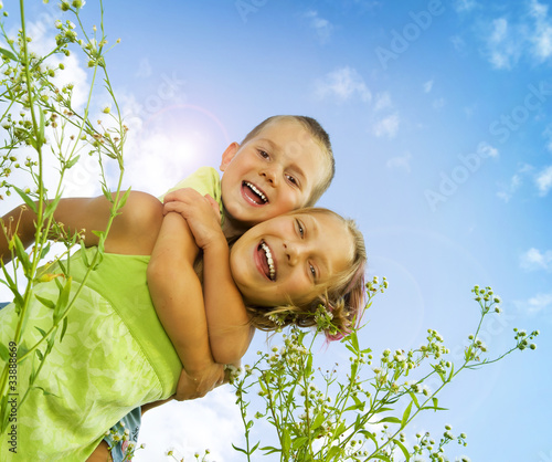 Photo: Happy Kids. Sister and Brother outdoor. Family Happy Kids. Sister and Brother outdoor. Family