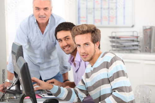 Foto: Young men working at their computers Young men working at their computers