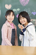 黒板に絵を描く小学生女子2人