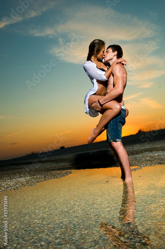 Photo: Couple on the beach at sunset Couple on the beach at sunset