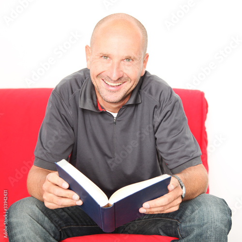 Foto: glücklicher Mann zuhause mit Buch glücklicher Mann zuhause mit Buch