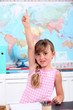 a little girl putting one's hand up in a classroom