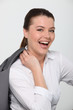 Laughing businesswoman with her jacket over her shoulder