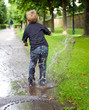 boy is jumping in a puddle
