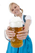 Foto: Hübsche blonde Frau im Wiesn-Dirndl prostet mit Masskrug zu Hübsche blonde Frau im Wiesn-Dirndl prostet mit Masskrug zu