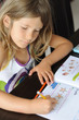 petite fille, studieuse faisant son cahier de vacances