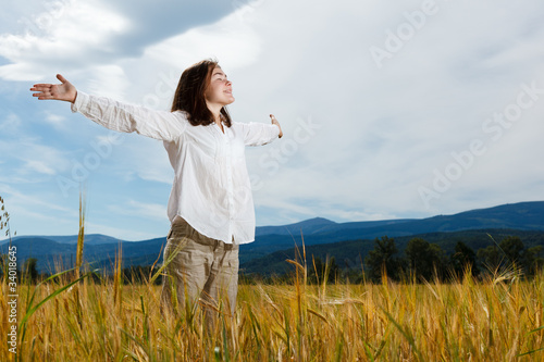 Photo: Girl holding arms up against blue sky Girl holding arms up against blue sky