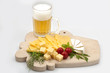 Various types of cheese on a wooden board with beer Various types of cheese on a wooden board with beer