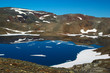 Foto: Lake in barren and partly snowcovered mountain scenery Lake in barren and partly snowcovered mountain scenery