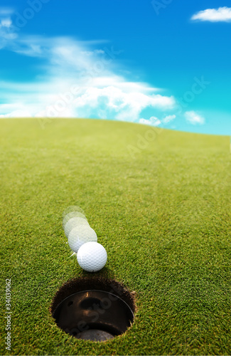 Photo: golf ball on lip of cup of lovely beautiful golf course golf ball on lip of cup of lovely beautiful golf course
