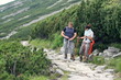 Young couple of hikers looking at a map in the mountains