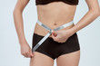 Photo: femme mesurant son ventre plat en boxer marron femme mesurant son ventre plat en boxer marron