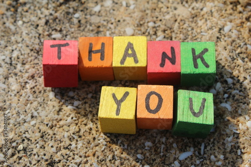 Photo: Thank you written with wood cubes, at a rocky beach Thank you written with wood cubes, at a rocky beach