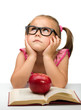 Little girl is sitting bored with a book
