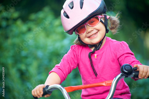 Foto: Adorable girl in pink safety helmet Adorable girl in pink safety helmet