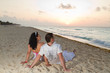 Photo: Young couple watching sunrise on the beach Young couple watching sunrise on the beach