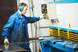 worker operating guillotine shears machine