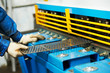 worker's hand operating guillotine shears machine
