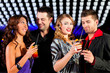 Group of party people with cocktails in a bar or club having fun