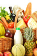 Groceries in wicker basket isolated on white Groceries in wicker basket isolated on white