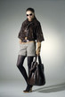 fashion model in autumn/winter clothes holding handbag posing fashion model in autumn/winter clothes holding handbag posing
