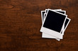 Empty instant photos on wooden table background