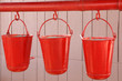 Three old, red fire buckets used to put out fires Three old, red fire buckets used to put out fires