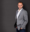 Cool businessman standing on grey background
